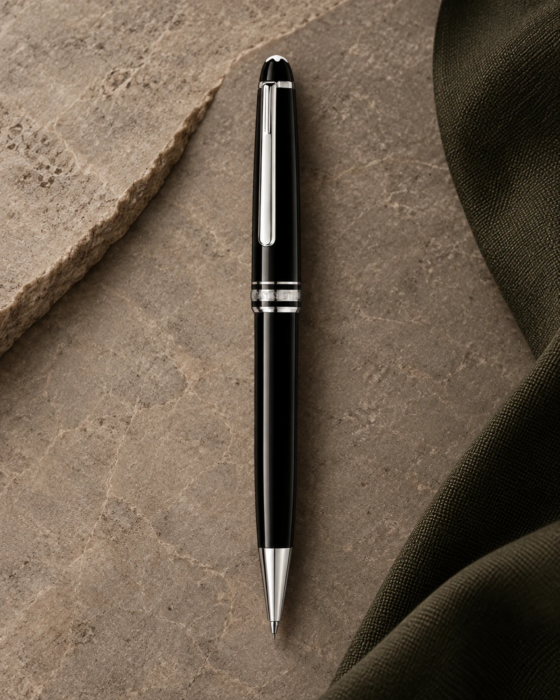 Portamine Montblanc Meisterstück Classique nero con finitura platino su pietra taupe e tessuto verde oliva.